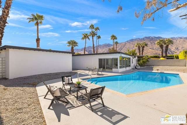 view of swimming pool with a mountain view, a patio area, and a sunroom