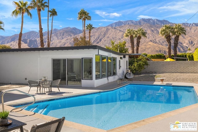 view of swimming pool with a mountain view and a patio area