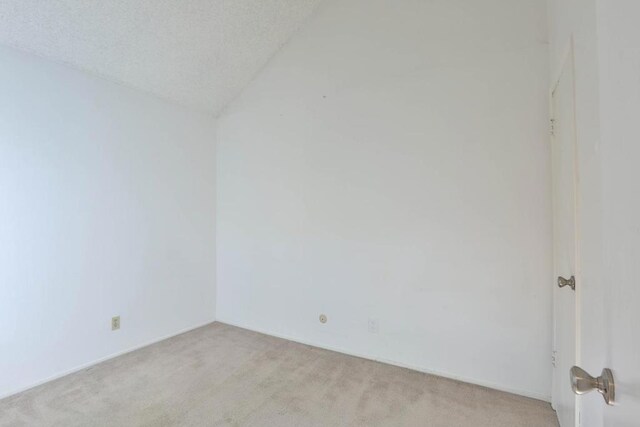 unfurnished room with a textured ceiling and light carpet