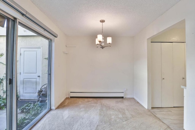 empty room featuring light carpet, a textured ceiling, an inviting chandelier, and a baseboard heating unit