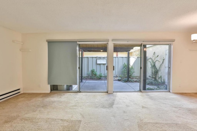 carpeted spare room featuring a textured ceiling and baseboard heating