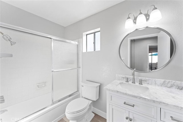 full bathroom featuring vanity, enclosed tub / shower combo, and toilet