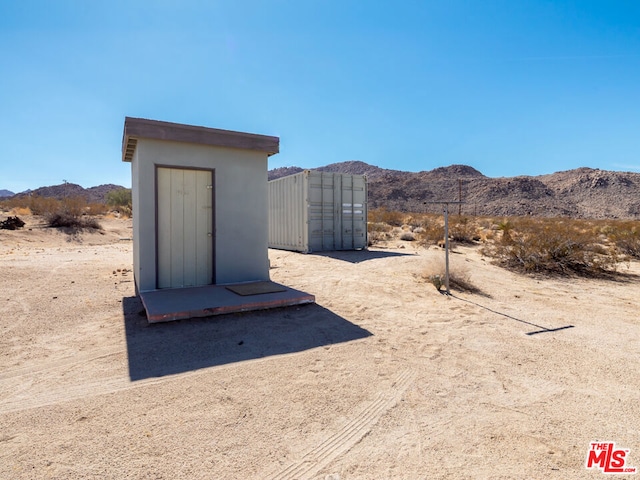 exterior space with a mountain view and a storage unit