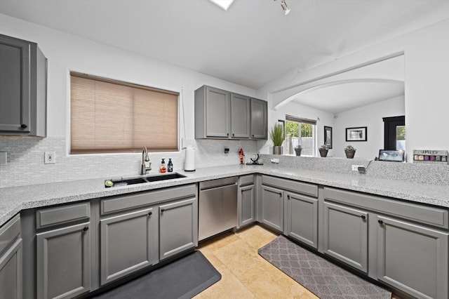 kitchen with gray cabinets, light tile patterned flooring, dishwasher, lofted ceiling, and sink