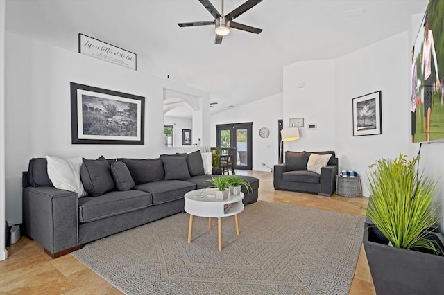 tiled living room featuring vaulted ceiling, french doors, and ceiling fan