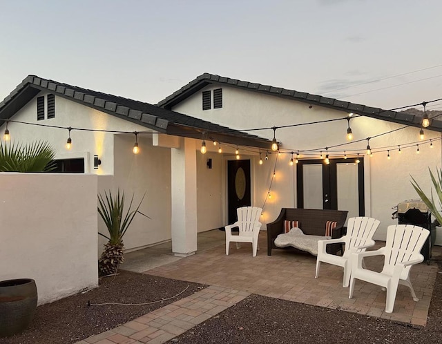 back house at dusk with a patio area