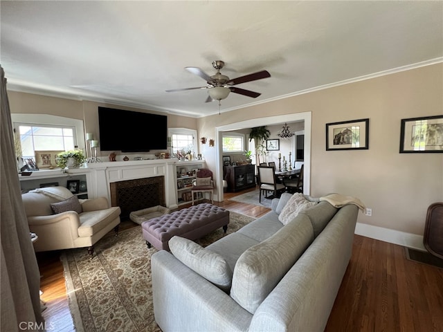 living room featuring wood-type flooring, ceiling fan, and ornamental molding