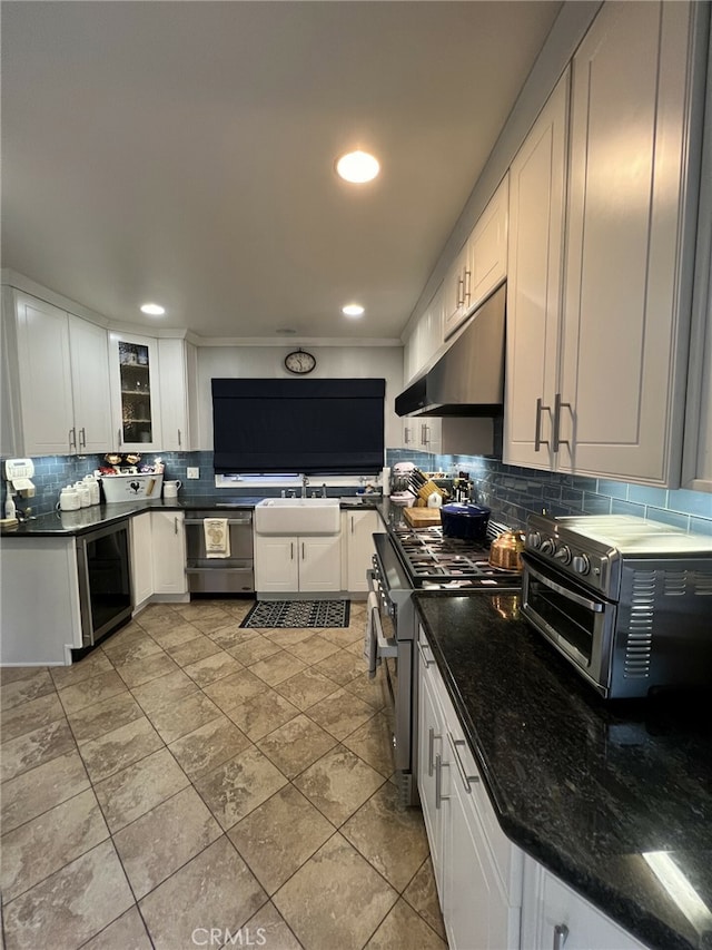 kitchen featuring white cabinets, decorative backsplash, and stainless steel range