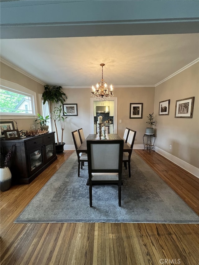 dining area featuring hardwood / wood-style floors, an inviting chandelier, and ornamental molding