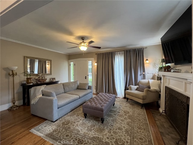 living room with ceiling fan, wood-type flooring, and ornamental molding