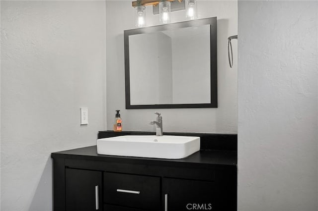 bathroom with vanity and a textured wall