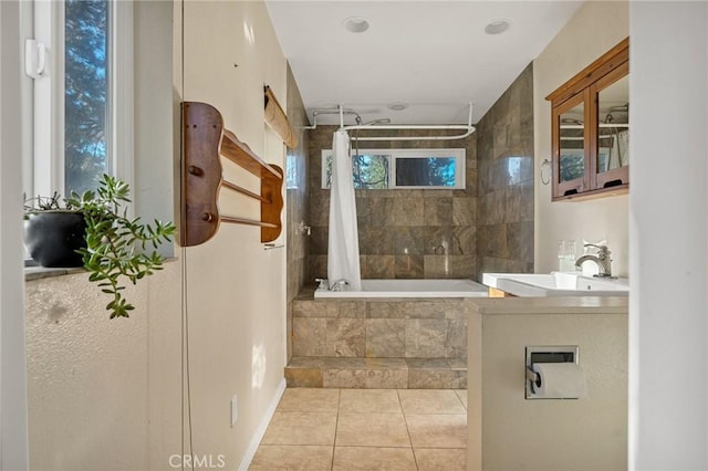 full bathroom with tiled shower / bath, a sink, and tile patterned flooring