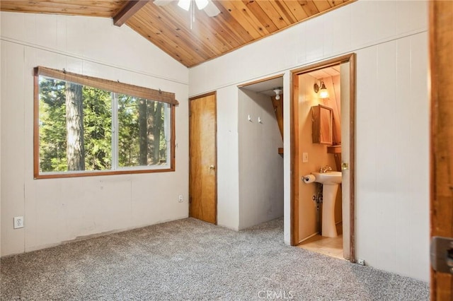 unfurnished bedroom featuring connected bathroom, wooden ceiling, carpet flooring, a sink, and vaulted ceiling with beams