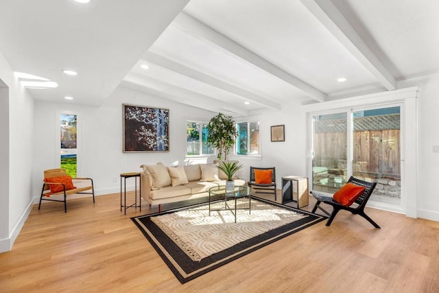 living area with light hardwood / wood-style floors and vaulted ceiling with beams