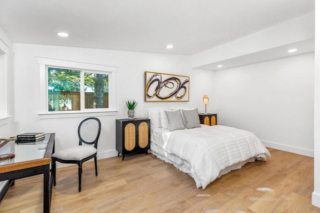 bedroom with vaulted ceiling and light wood-type flooring