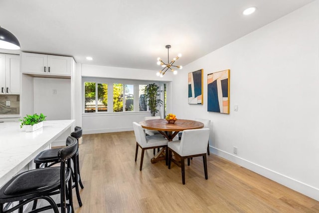 dining area featuring light wood-type flooring and a notable chandelier