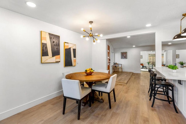 dining space featuring an inviting chandelier and light hardwood / wood-style floors