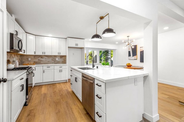 kitchen featuring stainless steel appliances, decorative backsplash, white cabinetry, and sink