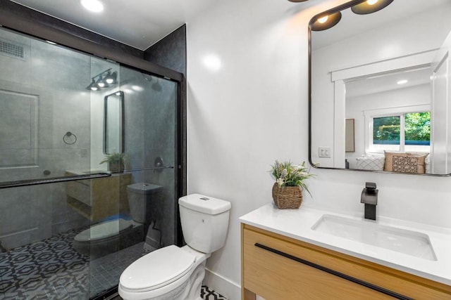 bathroom with toilet, walk in shower, and vanity