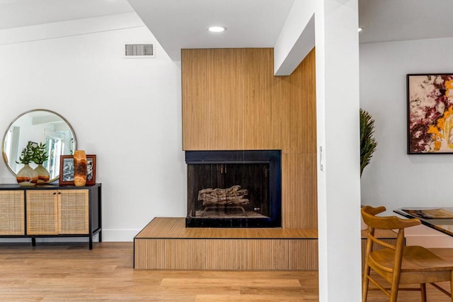 room details with a multi sided fireplace and hardwood / wood-style flooring