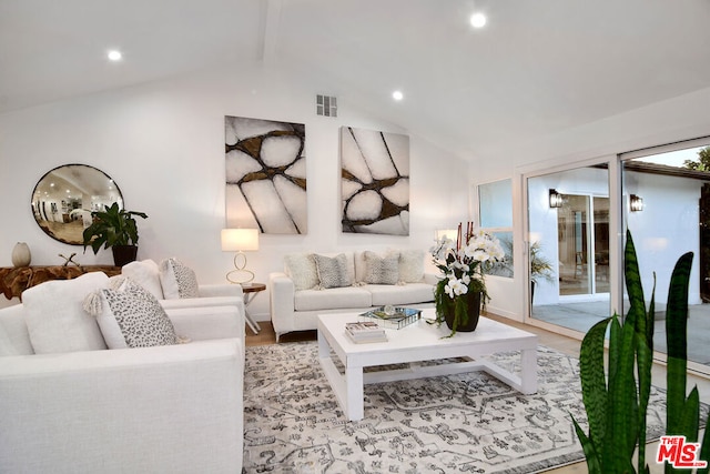 living room featuring vaulted ceiling with beams and light hardwood / wood-style floors