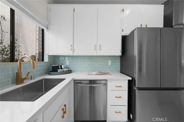 kitchen with tasteful backsplash, white cabinetry, sink, and appliances with stainless steel finishes