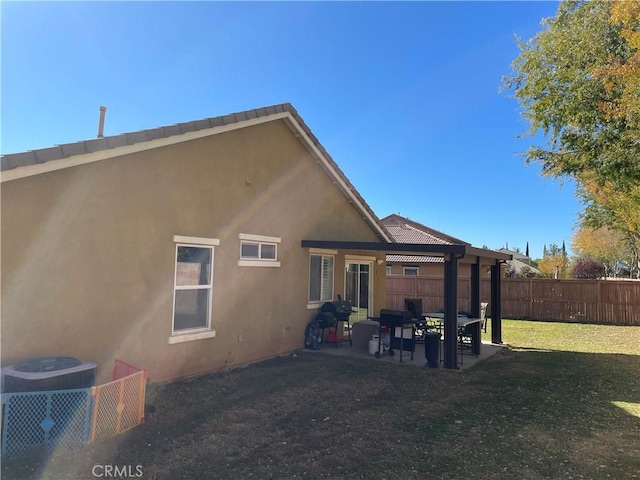 back of house with a yard and a patio