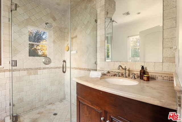 bathroom with decorative backsplash, vanity, and a shower with door