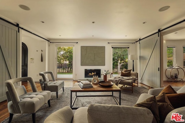 living room featuring a barn door and hardwood / wood-style flooring