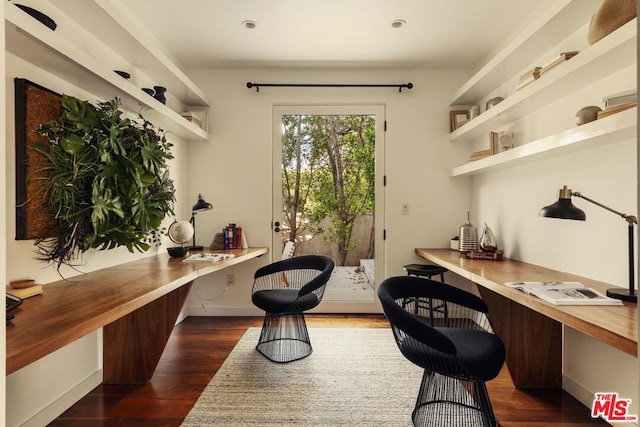 office with dark hardwood / wood-style floors and built in desk