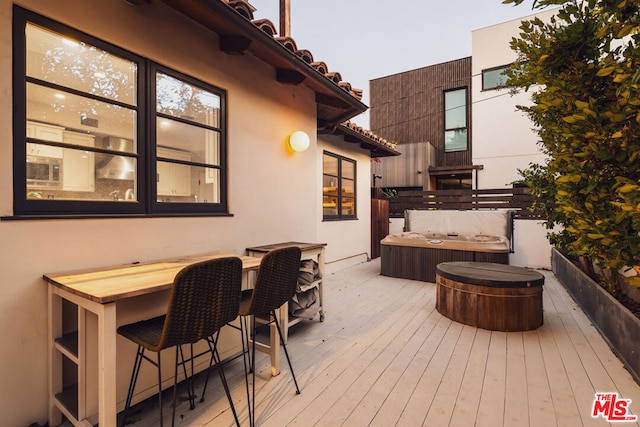 deck at dusk with a covered hot tub