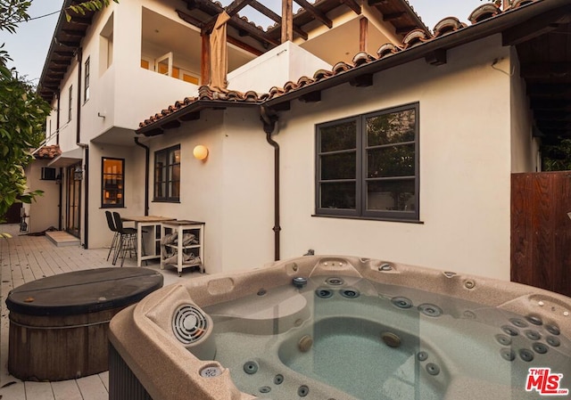 exterior space featuring a wooden deck and a hot tub