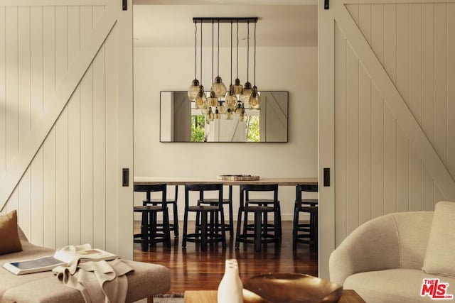 living room featuring a barn door and dark wood-type flooring