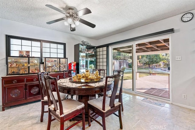 dining area featuring a textured ceiling, a wealth of natural light, and ceiling fan