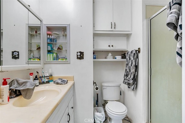 bathroom with vanity, toilet, and a shower with door