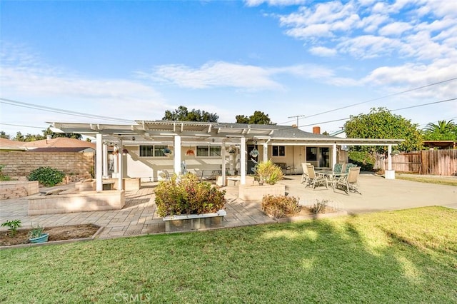 rear view of property featuring a yard, a pergola, and a patio