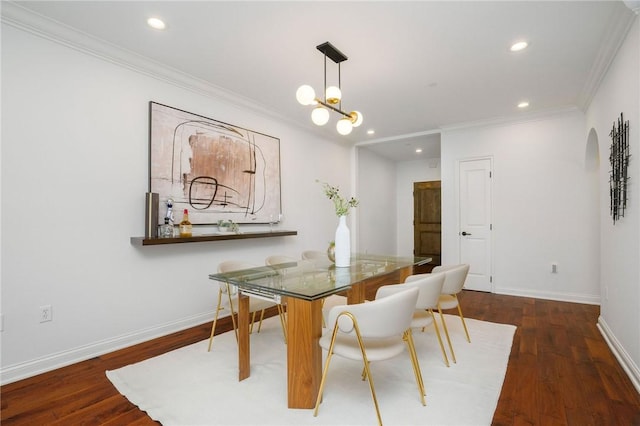 dining area with dark hardwood / wood-style flooring, ornamental molding, and a notable chandelier