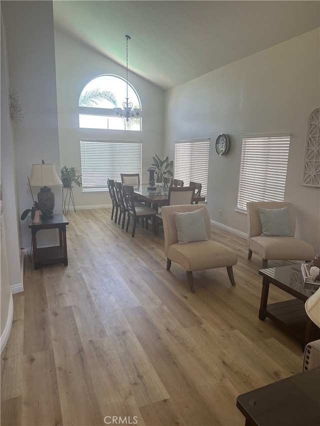 sitting room with light hardwood / wood-style floors and high vaulted ceiling