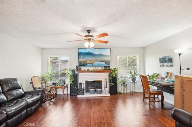 living room with dark hardwood / wood-style floors, ceiling fan, and a textured ceiling