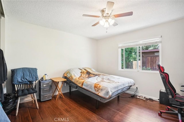 bedroom featuring a textured ceiling, ceiling fan, and dark wood-type flooring