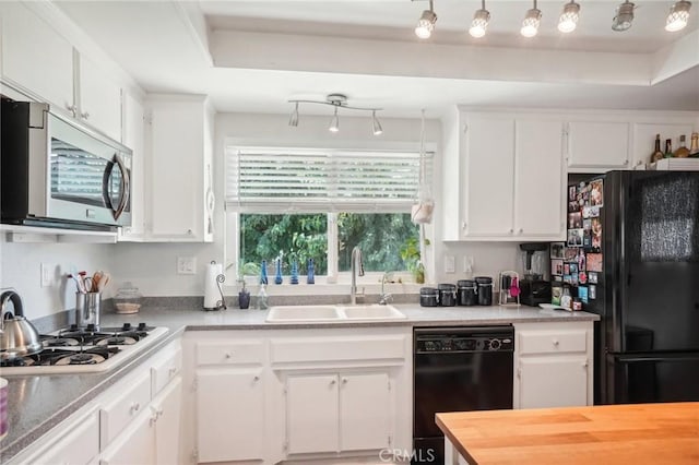 kitchen with black appliances, sink, a raised ceiling, and white cabinets