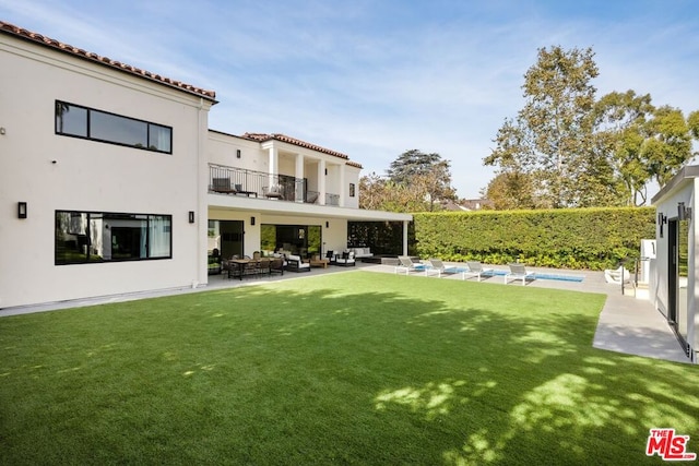 view of yard with a fenced in pool, outdoor lounge area, a balcony, and a patio