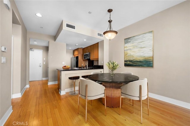 dining area featuring sink and light wood-type flooring