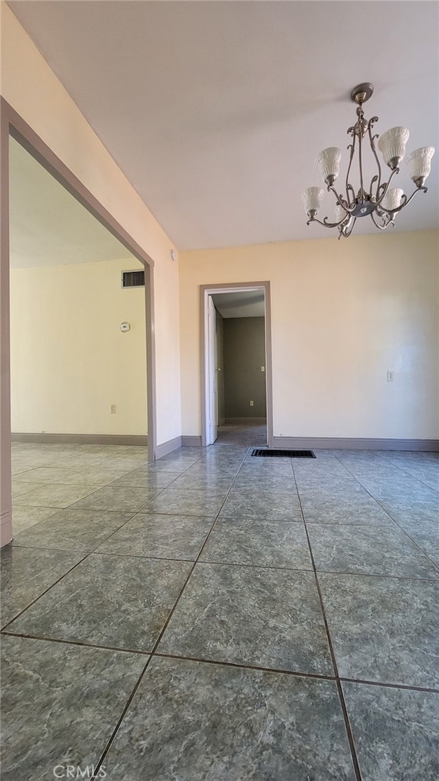 unfurnished room featuring a notable chandelier