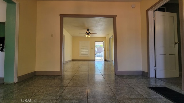 tiled spare room with ceiling fan