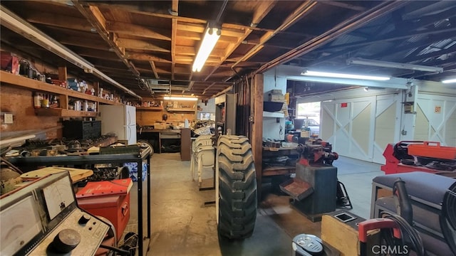 basement featuring a workshop area and white refrigerator