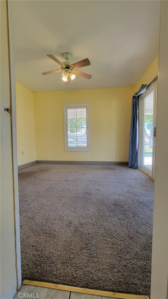 carpeted empty room featuring ceiling fan and a healthy amount of sunlight