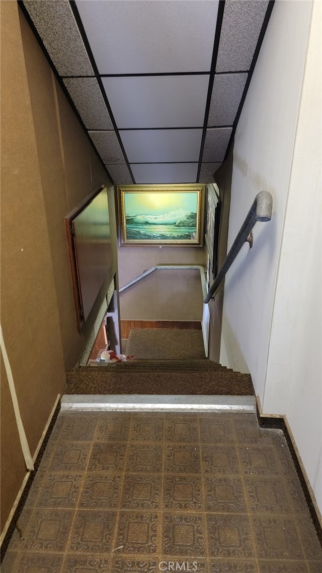 staircase featuring a paneled ceiling