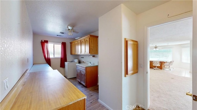 kitchen with washer and dryer, a textured ceiling, plenty of natural light, and sink