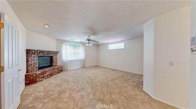 unfurnished living room with light carpet, ceiling fan, a textured ceiling, and a brick fireplace